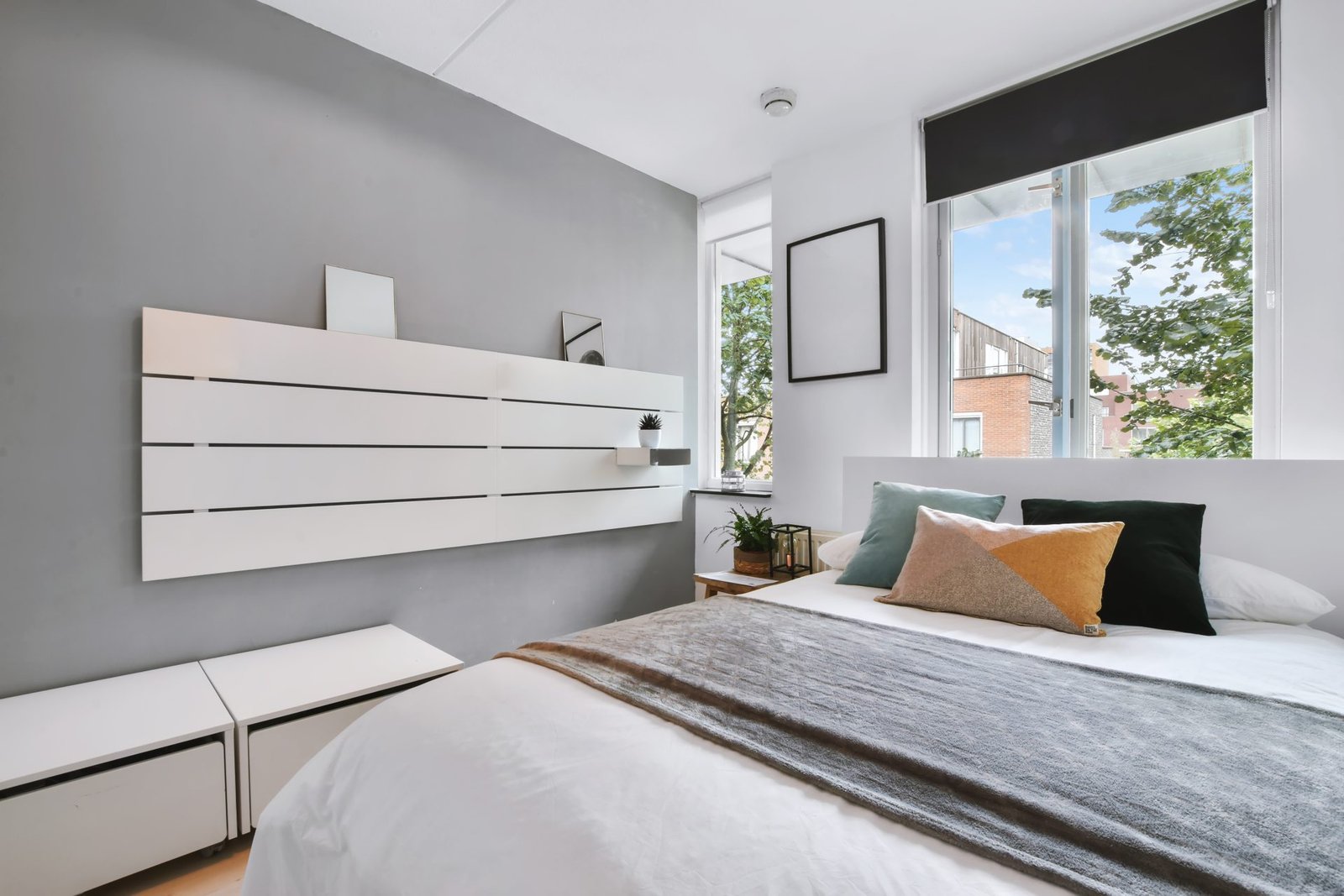 Modern bedroom with white furniture and cozy bedding.